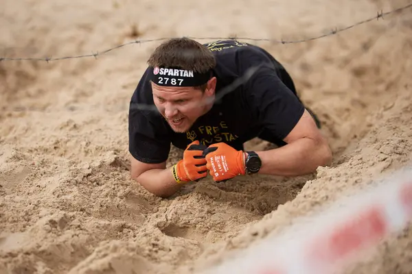 Ukrainischer Mann Kriecht Auf Sand Unter Dem Stacheldraht Während Des Stockfoto