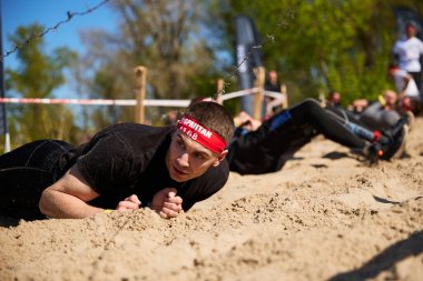 Kyiv 'deki Sparta Yarışı' nda dikenli tellerin altında kum üzerinde yuvarlanan sporcular - 20 Nisan 2024