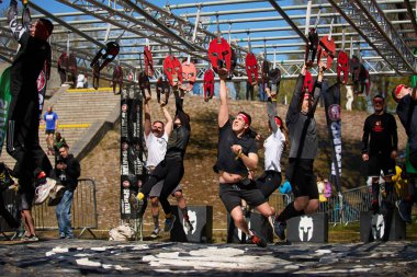 Bir grup sporcu, 20 Nisan 2024 'te Kyiv' deki Sparta Yarışı 'nda çok platformlu salıncakta sallanmak için yarışıyor.