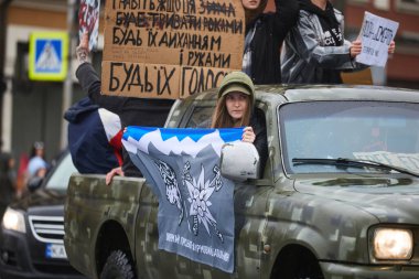 Ukraynalı aktivist 10. Dağ Saldırı Tugayı bayrağıyla Kyiv 'de 21 Nisan 2024' te düzenlenen mitinge katılıyor.