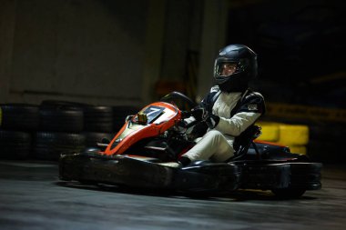 Kadın Go Kart yarışçısı kapalı bir pistte hızlı sürüyor. Kyiv - 26 Ocak 2024