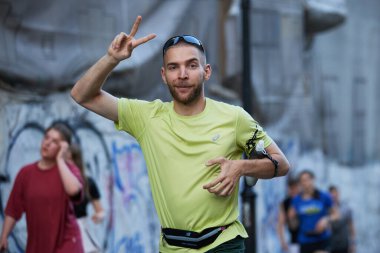 Neşeli koşucu, Kyiv 'deki şehir maratonu sırasında bir zafer jesti gösteriyor - 1 Haziran 2024