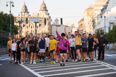 Yazın ilk günü Kyiv 'de sabah koşusu sırasında yolun ortasında poz veren büyük bir grup sporcu - 1 Haziran 2024