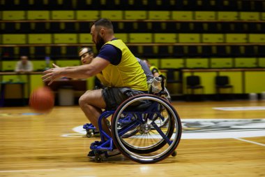 Uyumlu basketbol maçı sırasında tekerlekli sandalyede salya akıtan yaralı bir sporcu. Kyiv - 12 Aralık 2023