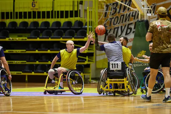 stock image Adaptive basketball game. Players in wheelchairs throwing a ball on court. Kyiv - 12 December,2023