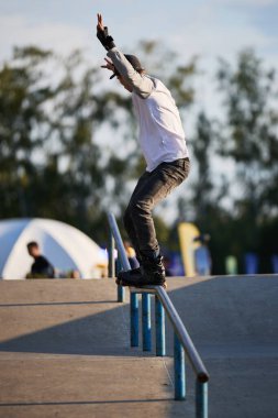 Paten yapan paten, bir paten parkında tırabzanı gıcırdatıyor. Ekstrem yaz sporları yarışması. Kyiv - 4 Ağustos 2024