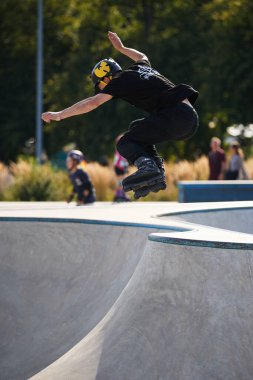 Paten havuzunda paten kayarken. Beton bir kaykay parkında rampadan atlayan agresif bir patenci. Kyiv - 4 Ağustos 2024