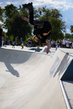 Patenli patenci kaykay havuzunda vida takla atıyor. Sinirli patenci bir kaykay parkında 540 mantar dönüşü yapıyor. Kyiv - 4 Ağustos 2024