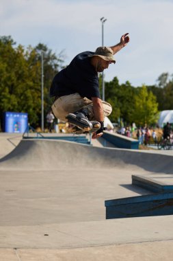 Patenci havada dilsiz yakalama numarası yapıyor. Paten parkına atlayan dahili bir patenci. Kyiv - 4 Ağustos 2024