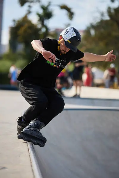 stock image Roller grinding in a skate pool. Aggressive in-line skater performing bs unity grind on coping rail. Kyiv - 4 August,2024