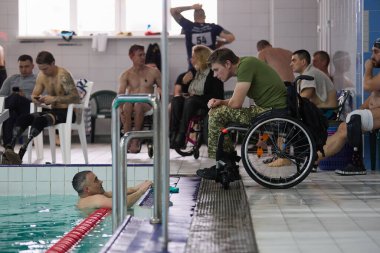 Yaralı Ukraynalı gaziler yüzme havuzunda Hava Kuvvetleri denemelerinde konuşuyorlar. Kyiv - 12 Aralık 2023