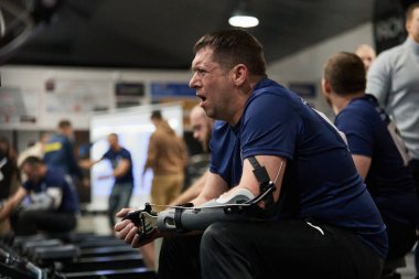 Kolu kesilmiş Ukraynalı gazi, Concept2 makinesinde bir kürek yarışında yarışıyor. Kyiv - 13 Aralık 2023