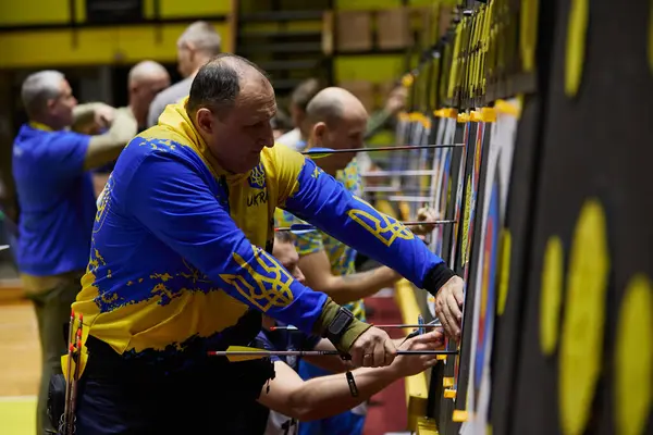 Stock image Archers pick arrows from targets during para archery competition in Ukraine. Kyiv - 14 December,2023