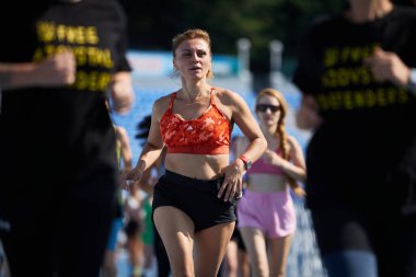 Kyiv 'deki açık spor müsabakası sırasında bir grup sporcuyla mesafe koşan bir bayan - 10 Ağustos 2024