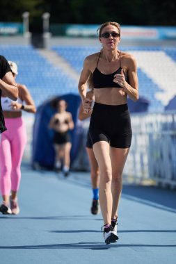 Genç bir kadın yazın stadyumda maraton koşuyor. Kyiv - 10 Ağustos 2024