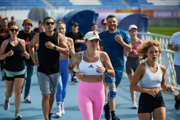 Bir grup Ukraynalı sporcu yaz aylarındaki fonksiyonel antrenman sırasında sprint mesafesinde koşuyor. Kyiv - 10 Ağustos 2024