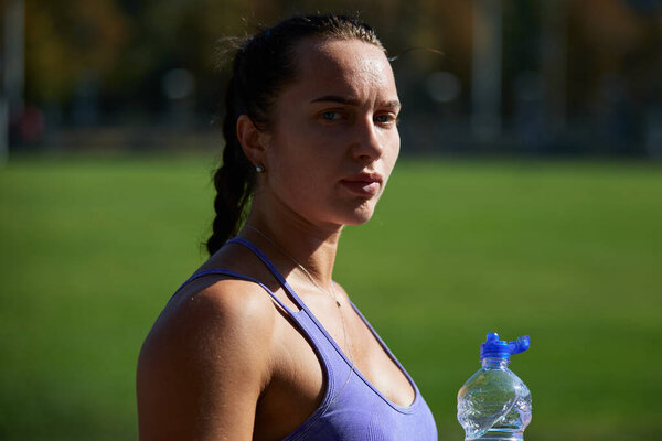 Молодой украинский спортсмен пьет воду после тренировки на открытом воздухе. Киев - 7 сентября 2024 года