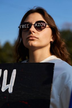 Özgür Azov yazan Ukraynalı kız güneş gözlüğü takıyor. Kyiv - 22 Eylül 2024