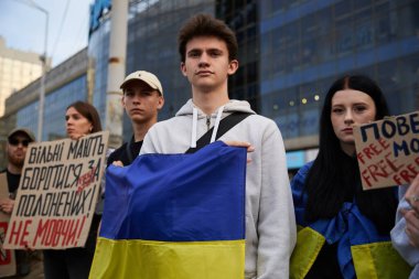 Genç Ukraynalı vatansever barış gösterisinde elinde ulusal bayrak ile poz veriyor. Kyiv - 15 Eylül 2024