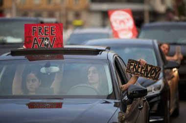 Ukraynalı kadınlar ellerinde Özgür Azov pankartlarıyla arabaya biniyorlar. Kyiv - 15 Eylül 2024