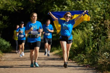 Neşeli Ukraynalı kadın Kyiv 'deki maraton koşusu sırasında ulusal bayrağıyla koşuyor - 25 Ağustos 2024