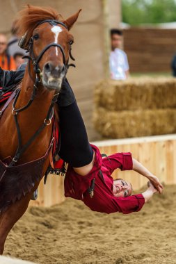 Kazak at üstünde sürükleme numarası. Etnospor Kultur Festivali 'nde gösteri yapan bir kadın. İstanbul - 11 Mayıs 2018