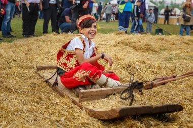 Happy Turkish boy riding on a sled attached to a horse at Etnospor Kultur Festivali. Istanbul - 11 May,2018 clipart