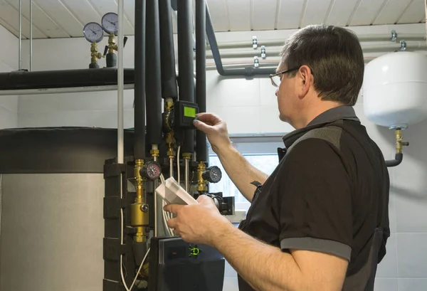 Technician Checks Heating System Boiler Room Private House lizenzfreie Stockfotos