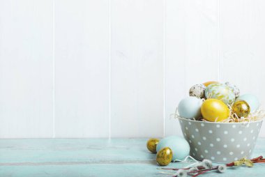 Paskalya arkaplanı, paskalya mavisi ve altın yumurtayla beyaz tahta duvarın önünde, yazı için yeri olan. Paskalya Arkaplanı