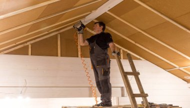 İnşaat işçisi termal olarak ahşap çerçeveli evi ahşap elyaf kaplama ve ısı yalıtımlı doğal kenevir maddesiyle yalıtıyor..