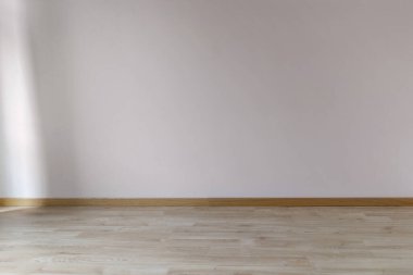 Moda renginde boyalı bir duvar. Pencerenin solundan güneş ışığı alıyor. Ahşap zemin, boş alan, tasarım için model..