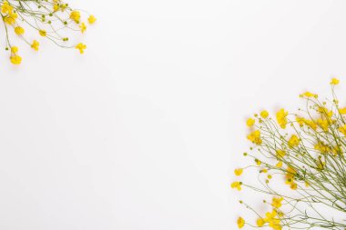 Narin yeşil sapları ve yaprakları etrafa saçılmış parlak sarı düğün çiçekleri buketi, temiz beyaz arka plan, bahar kutlamaları için minimalist, doğal çiçek kompozisyon