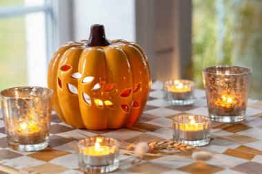 Mumlu sonbahar balkabağı dekoru, rahat higge atmosferi, parlayan ışık, mevsimlik ev içi, sonbahar havası, Cadılar Bayramı süsü, sıcak Ekim akşamı, kutlama kartı için şenlik sahnesi