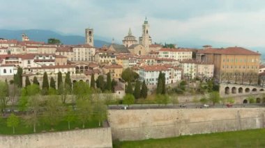 Scenic aerial view of Bergamo city northeast of Milan. Flying over Citta Alta, towns upper district, known by cobblestone streets and encircled by Venetian walls. Bergamo, Lombardy, Italy.
