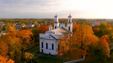 Beautiful aerial view of St. John the Baptists Church in Birzai surrounded by autumn vegetation on sunny fall day. Birzai, Lithuania.