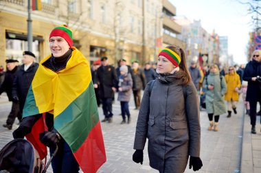 VILNIUS, LITHUANIA - 11 Mart 2022: Litvanya 'nın bağımsızlığını geri kazanmasının 32. yıldönümü münasebetiyle üç renkli Litvanya bayrakları taşıyan neşeli insanlar.