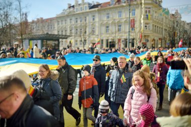 VILNIUS, LITHUANIA - 11 Mart 2022: Litvanya 'nın bağımsızlığını geri kazanmasının 32. yıldönümü münasebetiyle üç renkli Litvanya bayrakları taşıyan neşeli insanlar.