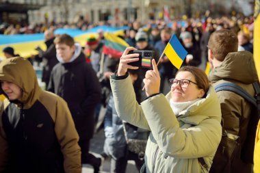 VILNIUS, LITHUANIA - 11 Mart 2022: Litvanya 'nın bağımsızlığını geri kazanmasının 32. yıldönümü münasebetiyle üç renkli Litvanya bayrakları taşıyan neşeli insanlar.