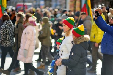 VILNIUS, LITHUANIA - 11 Mart 2022: Litvanya 'nın bağımsızlığını geri kazanmasının 32. yıldönümü münasebetiyle üç renkli Litvanya bayrakları taşıyan neşeli insanlar.