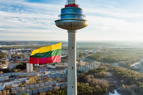 stock image VILNIUS, LITHUANIA - FEBRUARY 16, 2022: Giant tricolor Lithuanian flag waving on Vilnius television tower on the celebration of Restoration of the State Day in Vilnius.