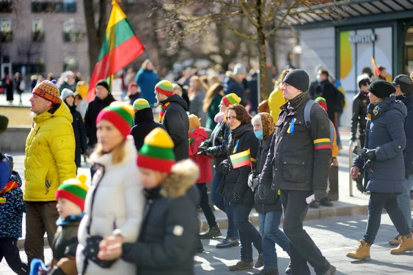 ヴィリニュス リトアニア 2022年3月11日 リトアニアが独立回復の32周年を迎えたことから トリコロール リトアニアの旗をお祝いのイベントで運ぶ陽気な人々 — ストック写真