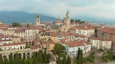 Scenic aerial view of Bergamo city northeast of Milan. Flying over Citta Alta, towns upper district, known by cobblestone streets and encircled by Venetian walls. Bergamo, Lombardy, Italy.