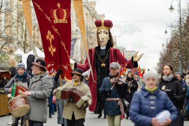 VILNIUS, LITHUANIA - 4 Mart 2022: Kaziuko muge veya Kaziukas, geleneksel Paskalya pazarı sırasında mizahi geçit törenine katılan neşeli insanlar, her Mart ayında Old Town sokaklarında el sanatları fuarı düzenleniyor.