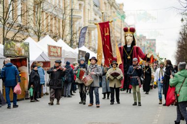 VILNIUS, LITHUANIA - 4 Mart 2022: Kaziuko muge veya Kaziukas, geleneksel Paskalya pazarı sırasında mizahi geçit törenine katılan neşeli insanlar, her Mart ayında Old Town sokaklarında el sanatları fuarı düzenleniyor.