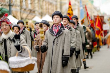 VILNIUS, LITHUANIA - 4 Mart 2022: Kaziuko muge veya Kaziukas, geleneksel Paskalya pazarı sırasında mizahi geçit törenine katılan neşeli insanlar, her Mart ayında Old Town sokaklarında el sanatları fuarı düzenleniyor.