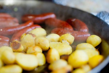 Litvanya 'nın Vilnius kentindeki bahar pazarında geleneksel kızarmış patates ve sosis pişiriliyor. Paskalya Festivali 'nde çeşitli sokak yemekleri.