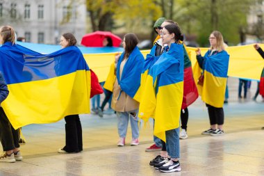 VILNIUS, LITHUANIA - MARCH 2, 2022: Peaceful demonstration against war and Russian invasion in Ukraine. People of Lithuania stand together in support of Ukraine with Ukrainian and Lithuanian flags. clipart