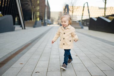 Komik çocuk güneşli bahar gününde dışarıda eğleniyor. Şehirdeki çocuk. Şehir parkında oynayan bir çocuk. Çocuklu aileler için aktif eğlence.