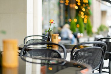 Litvanya 'nın Vilnius şehrinde güzel bir yaz gününde, gül çiçeğiyle süslenmiş açık hava restoran masası. Dışarıda yemek yemek..
