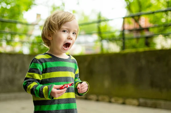 カラフルなおもちゃの車で屋外で遊んでかわいい幼児の男の子 おもちゃで遊ぶ小さな子供 — ストック写真